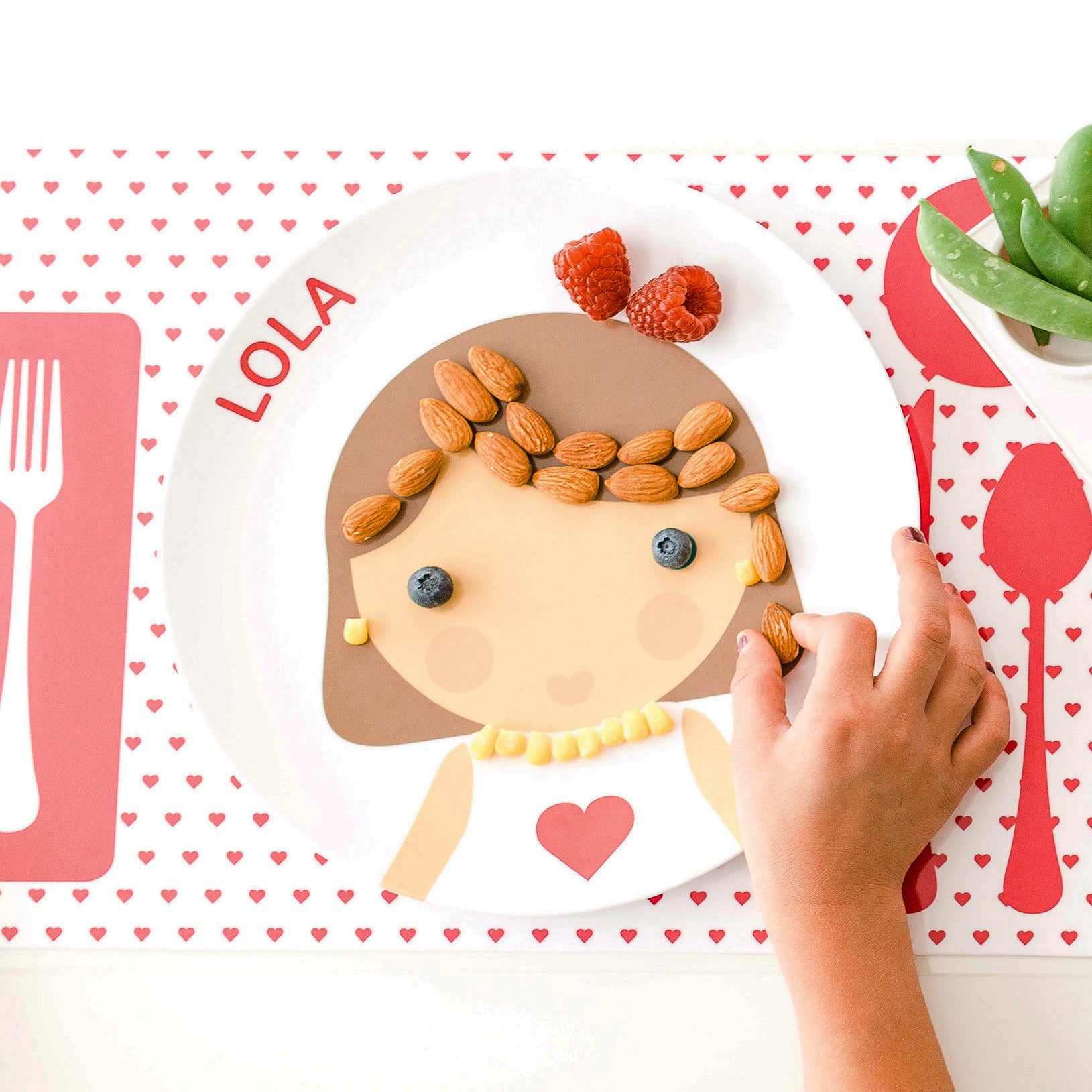 Girl decorating her Dylbug Personalized Little Me Face Plate for fun at mealtime, even for picky eaters