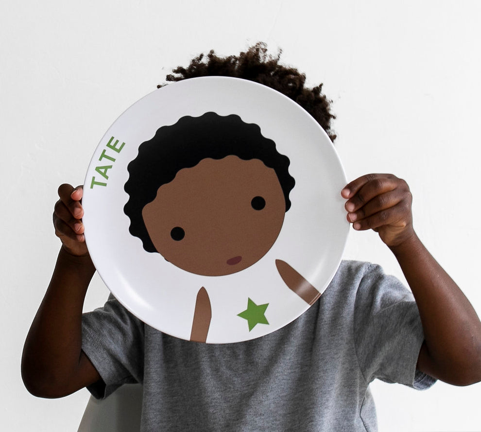 Little Boy holding up his Dylbug personalized Little Me Face Plate in green.