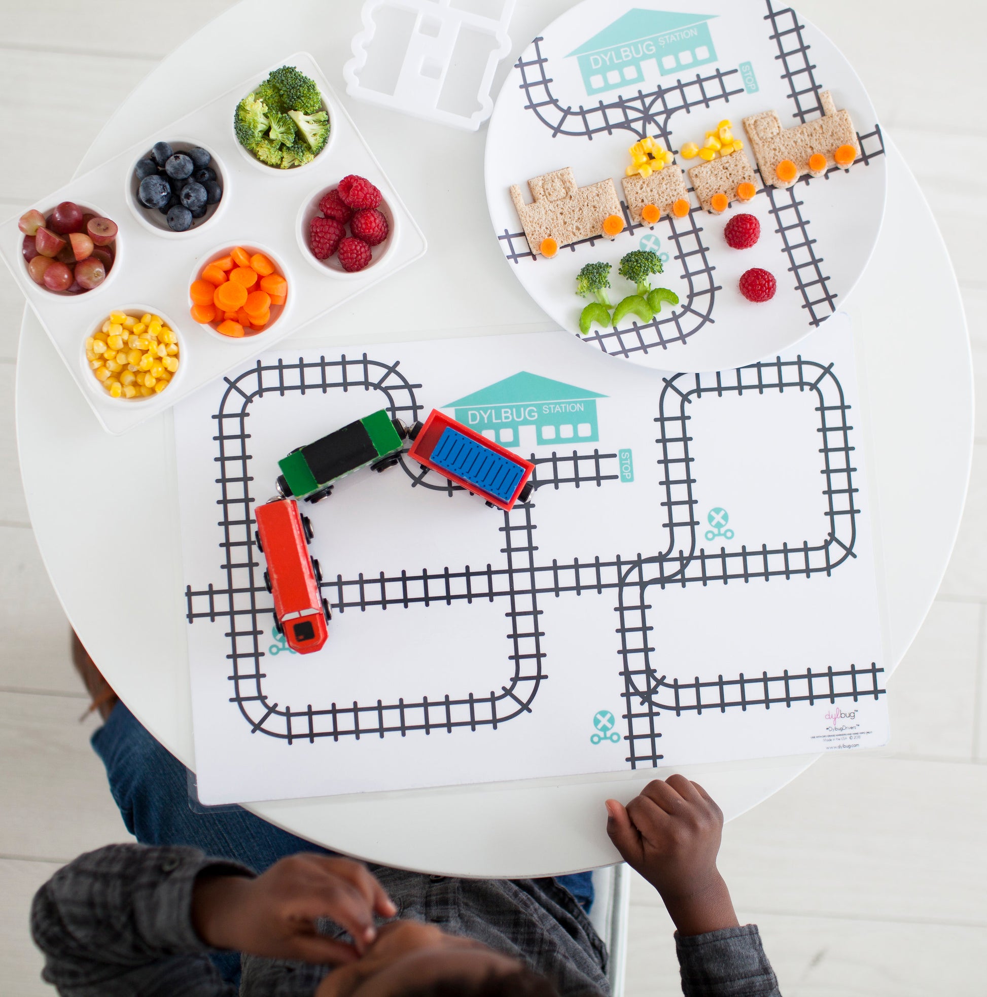Dylbug Personalized Train Plate and placemat in teal with trains and snack for kids. Perfect for playing, making healthy snacks fun, and keeping active kids and picky eaters happy at meal time.