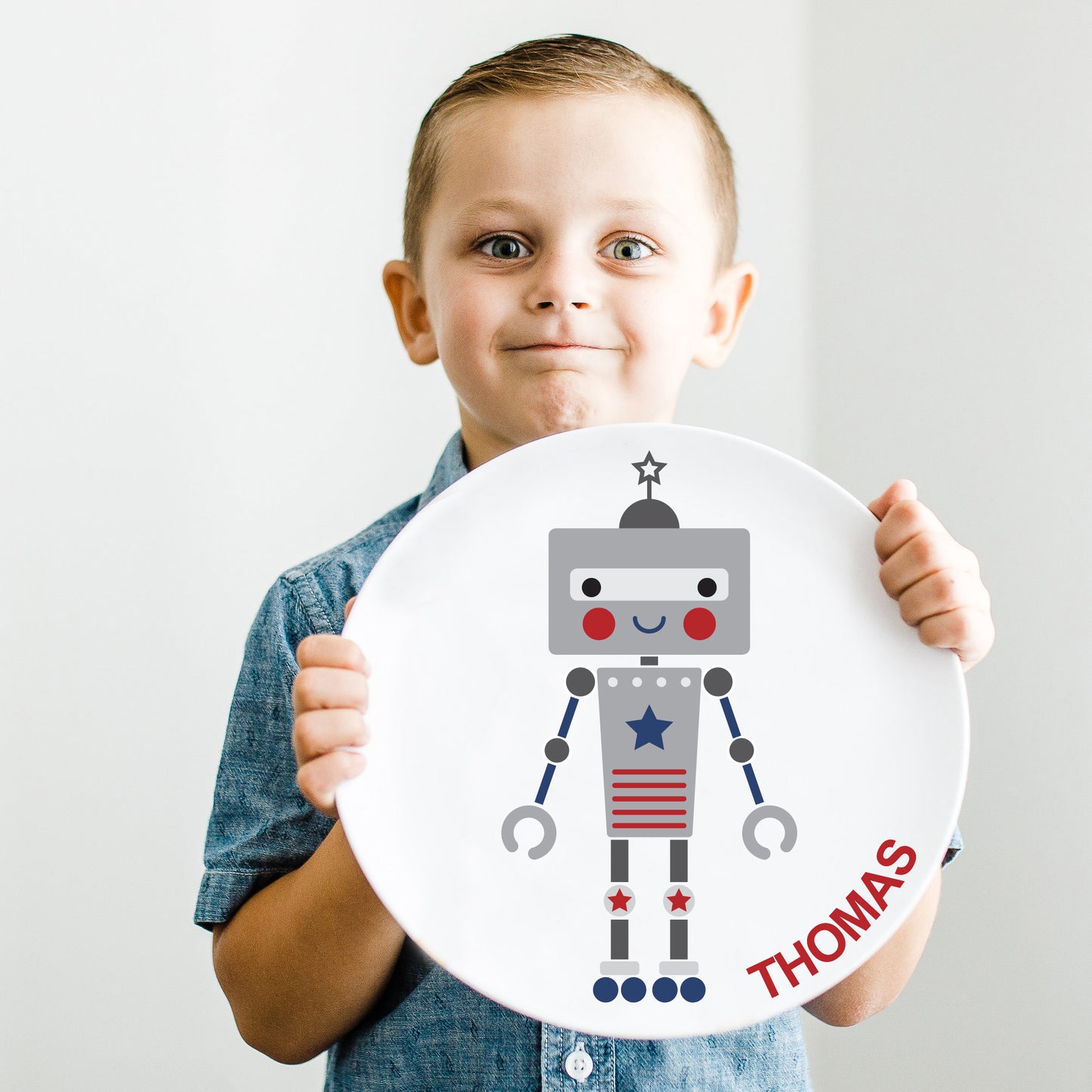 Little Boy holding up his Little Me Boy Robot plate.