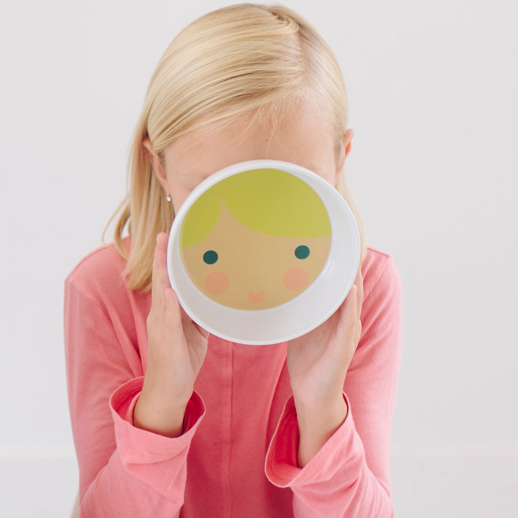 little girl holding up her little me girl face bowl with blond hair and blue eyes