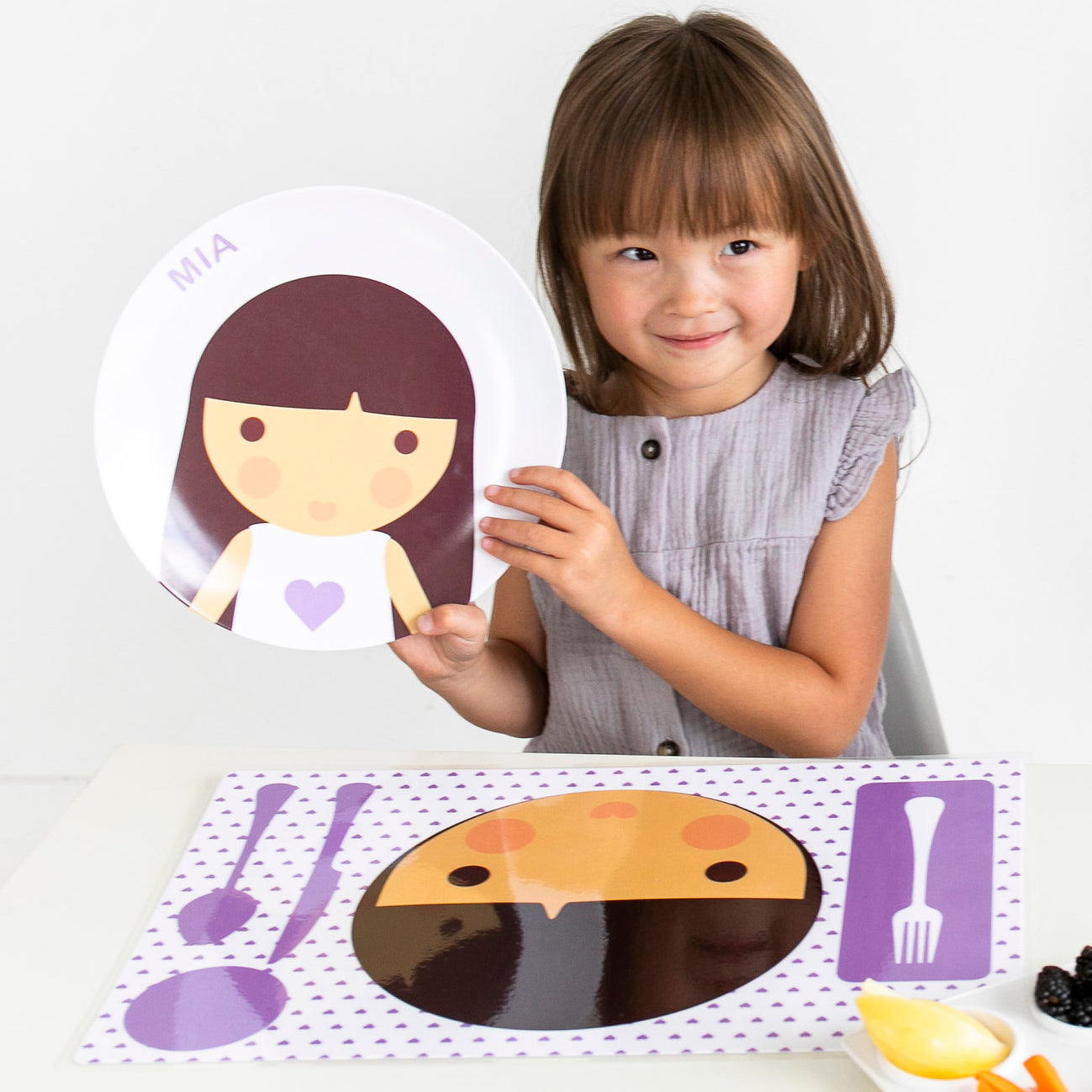 Little girl holding up her Dylbug Personalized Little Me Girl Face plate in purple