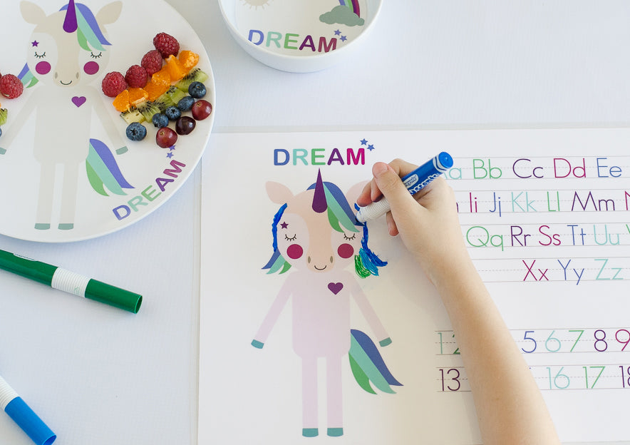 Unicorn Placemat by Dylbug with kids writing and coloring on activity side of the placemat