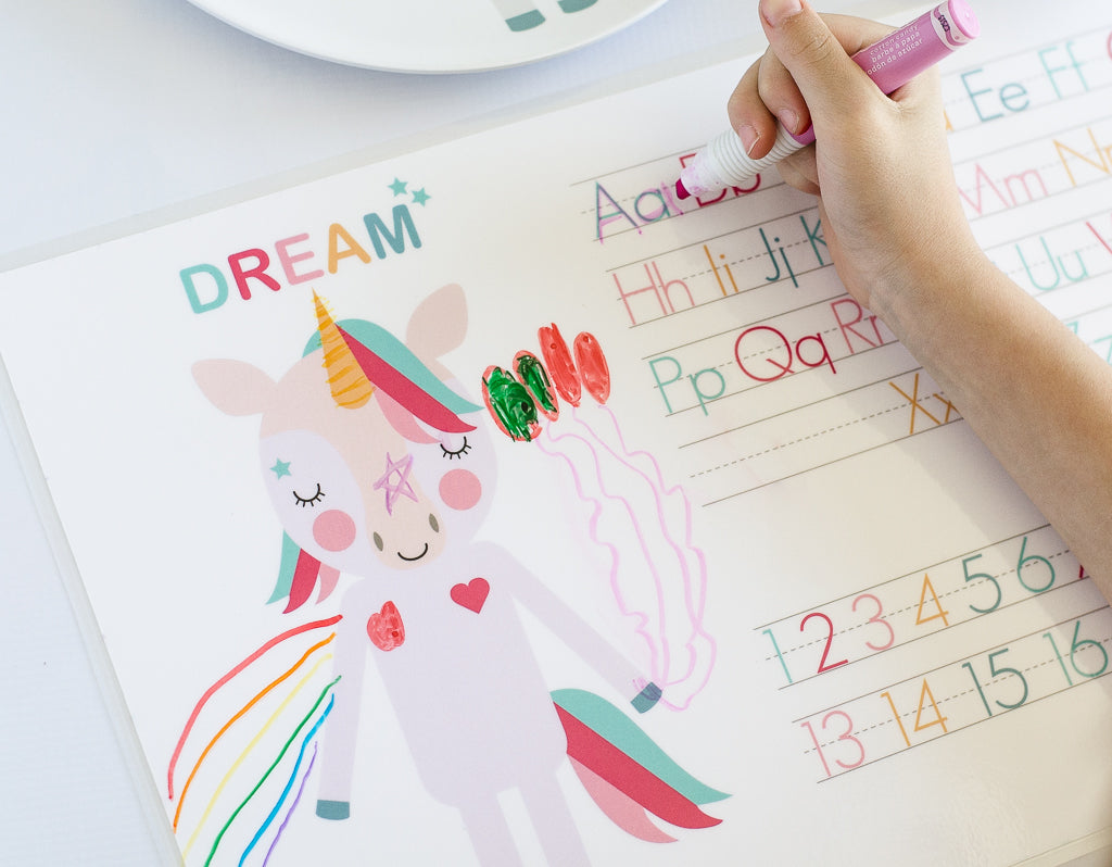 Unicorn Placemat by Dylbug with little girl writing and coloring with her placemat